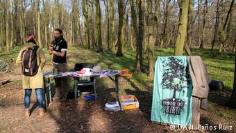 Forest activist Jus speaks with visitor to climate camp in the Hambach Forest (DW/I. Ba&ntilde;os Ruiz)