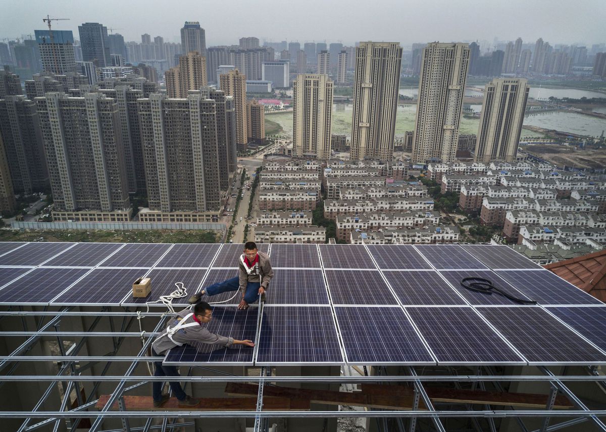 Chinese workers install rooftop solar panels in Wuhan, China.