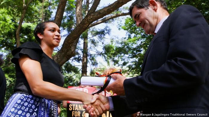 Murrawah Johnson shaking hand with a man in a suit (Wangan & Jagalingou Traditional Owners Council)