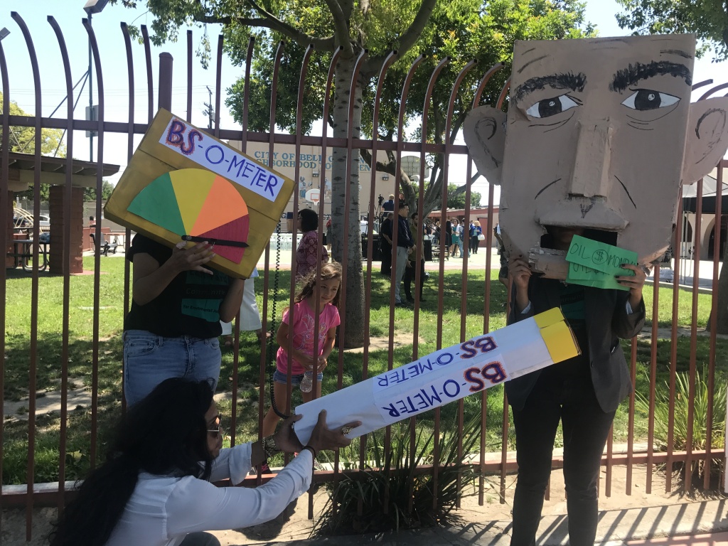 Environmental activists from the East Yards Communities for Environmental Justice pose with signs and protest materials depicting Governor Jerry Brown. 