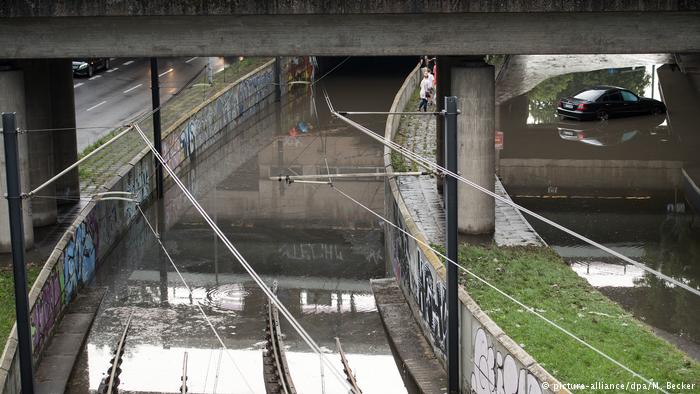 Bahngleise der Kölner Verkehrs-Betriebe (KVB) sind am 19.07.2017 in Köln (Nordrhein-Westfalen) überflutet. Daneben steht ein Auto im Wasser. (Foto: picture-alliance/dpa/M. Becker)