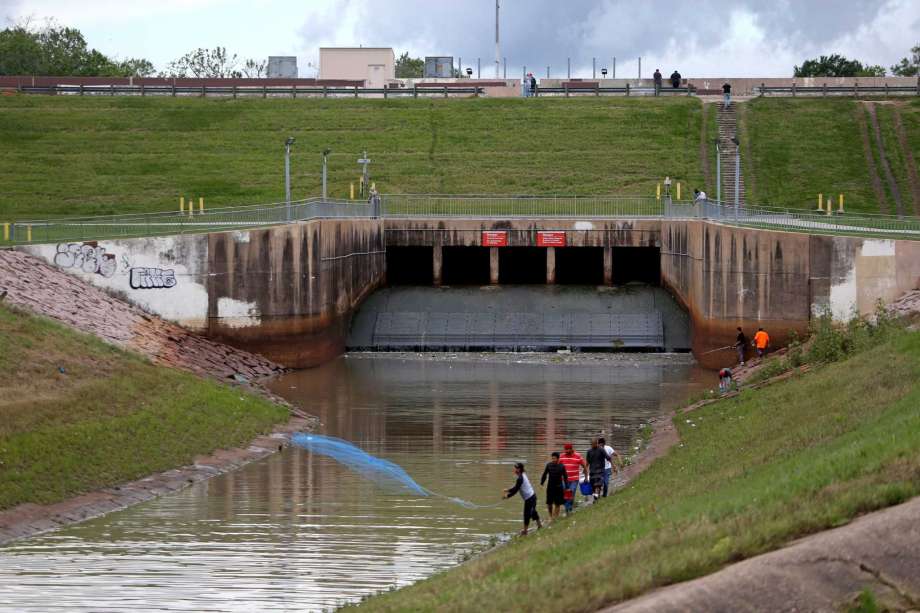 A man throws a cast net into the Buffalo Bayou with the Barker Dam and Barker Reservoir in the background in Houston, Texas. The Barker Reservoir and Barker Dam in conjunction with the Addicks Reservoir prevent downstream flooding of Buffalo Bayou in the City of Houston. ( Gary Coronado / Houston Chronicle ) Photo: Gary Coronado, Staff / &copy; 2015 Houston Chronicle