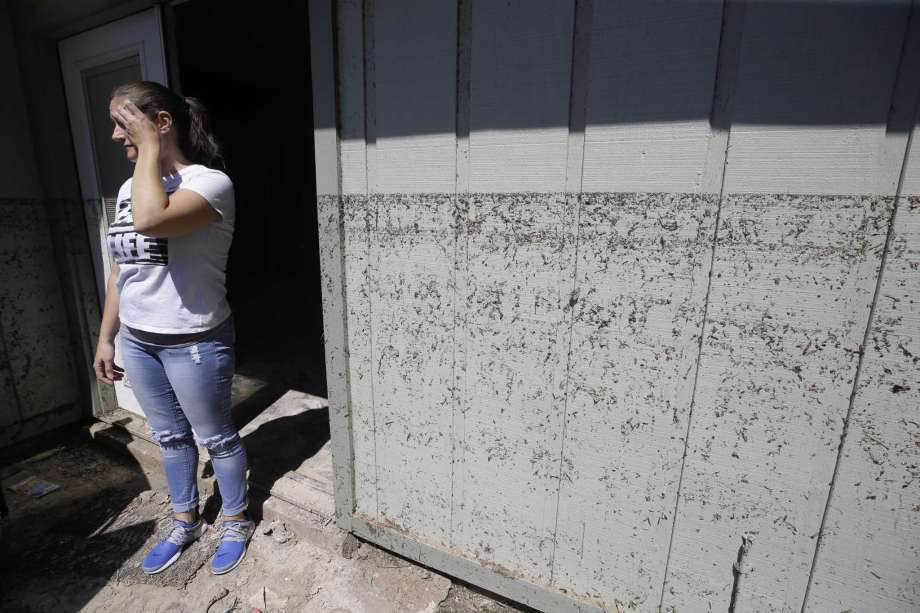 Kanani Hoover stands at the back door where the watermark is shown on her flooded Bear Creek Village home, which sits on the north edge of the Addicks Reservoir. Photo: Melissa Phillip, Staff / © 2017 Houston Chronicle