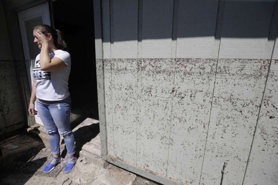 Kanani Hoover stands at the back door where the watermark is shown on her flooded Bear Creek Village home, which sits on the north edge of the Addicks Reservoir. Photo: Melissa Phillip, Staff / &copy; 2017 Houston Chronicle