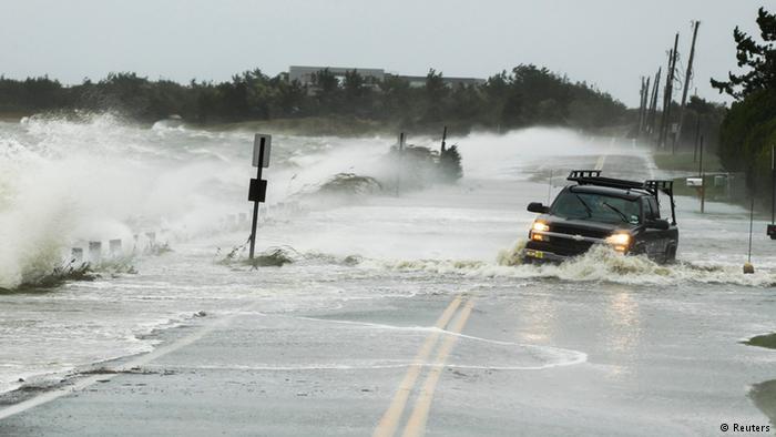 A truck drives through water pushed over a road by hurricane Sandy in Southampton, New York (Photo: REUTERS/Lucas Jackson)
