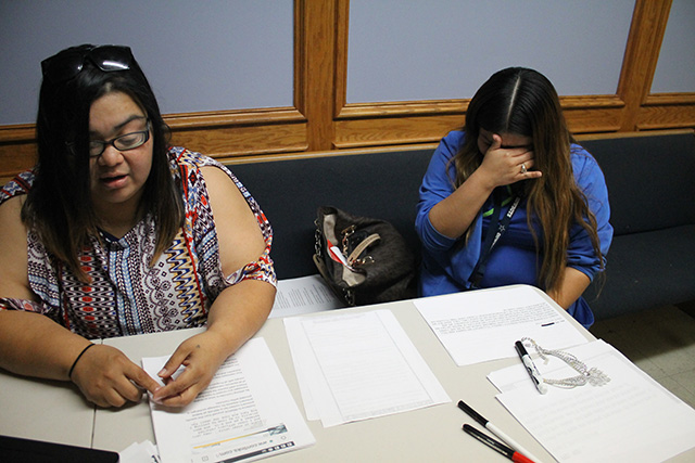 Ruth DeJob* sorts through a stack of emails sent from prisoners inside a federal complex in Beaumont, Texas, as Rachel Villalobos wipes back tears at the Anointing Power and Glory church in Dallas, Texas, September 5, 2017. (Photo: Candice Bernd)