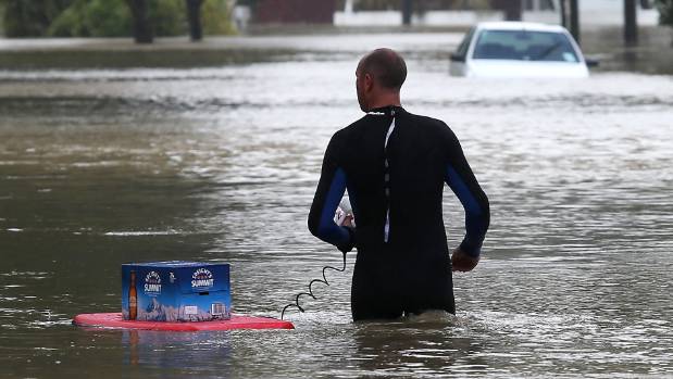 A Riverlaw Terrace resident floats the essentials on a bodyboard during the 2014 floods.