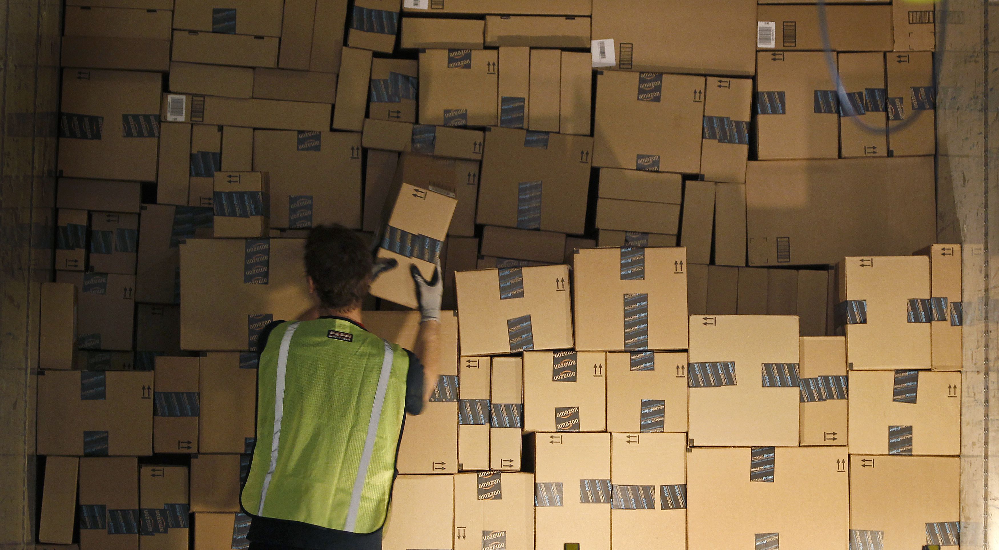A worker stacks a shipping trailer with boxed items for delivery at Amazon's distribution center in Phoenix, Arizona November 22, 2013. The web-based retailer is preparing for Cyber Monday, traditionally the busiest day of the year for online purchases, which falls on December 2 in 2013.