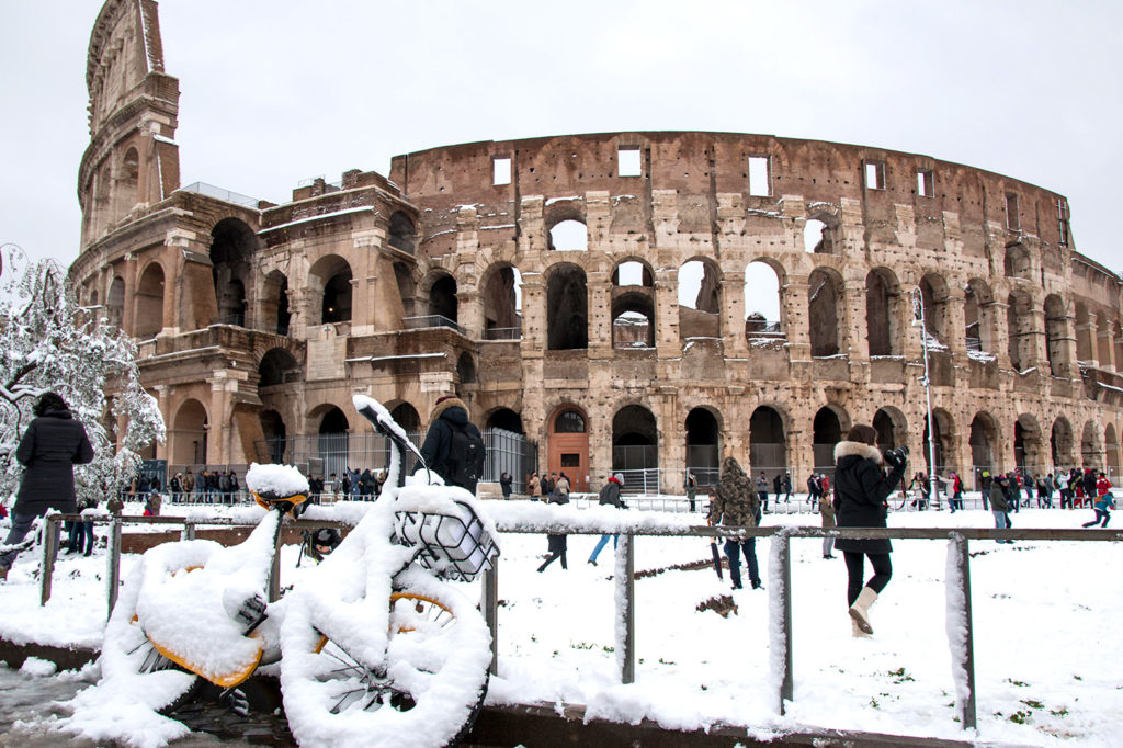 Roma, Italy. 26th Feb, 2018. People walk by the ancient Colosseum during a snowfall in Rome. Credit: CrowdSpark/Alamy Live News. M5X5B2