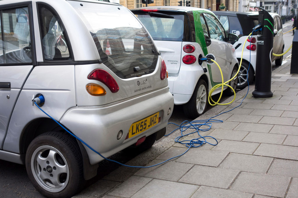 FJ1JDA Electric vehicles plugged into charging points on a road in London, UK. Credit: CAMimage / Alamy Stock Photo.