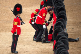 A soldier, overcome with heat, collapses during the Horse Guard Parade on 2 June 2018. Credit: Malcolm Park editorial / Alamy Stock Photo.