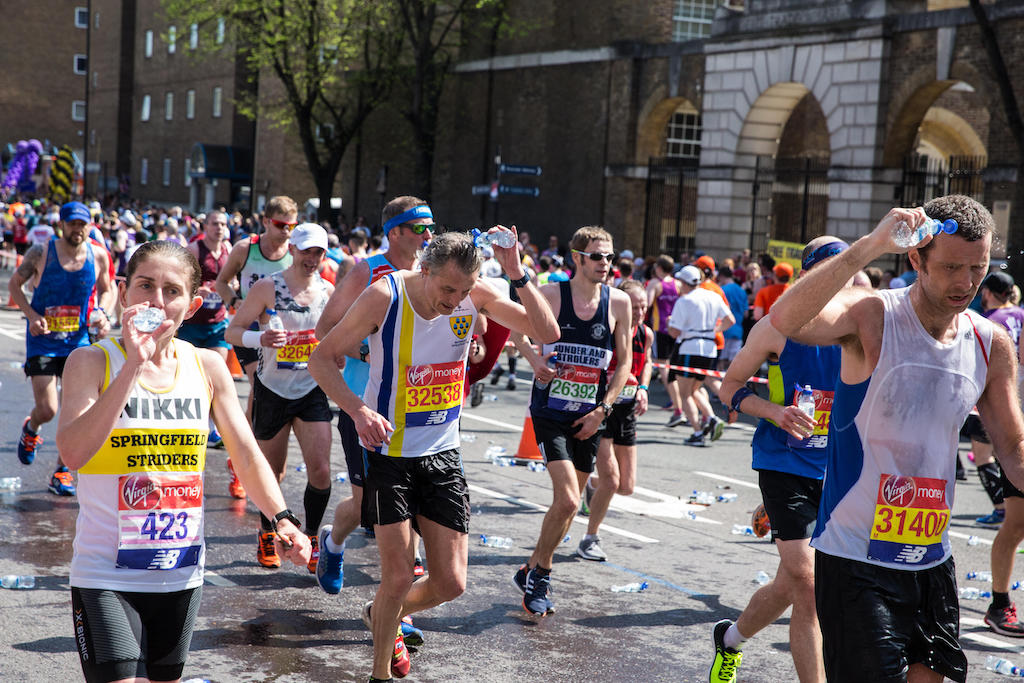 Runners take on water during the 2018 Virgin Money London Marathon.