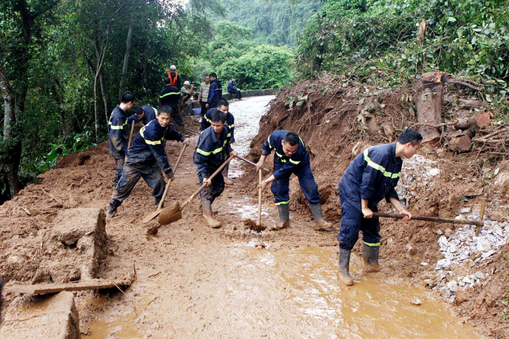Emergency response workers clear a road damaged by landslide after heavy rainfall in Hai Phong city, northern Vietnam, July 30, 2015. Credit: Xinhua / Alamy Stock Photo. EYK0B7