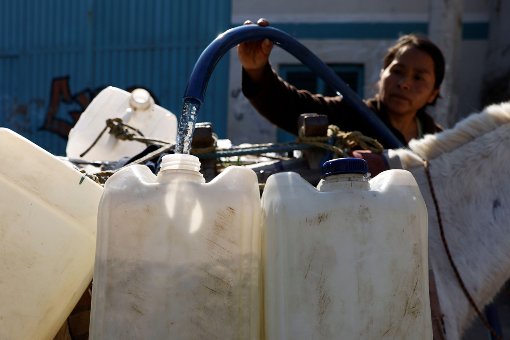 A lady fills tanks with water for her family as as drought takes hold of Mexico City